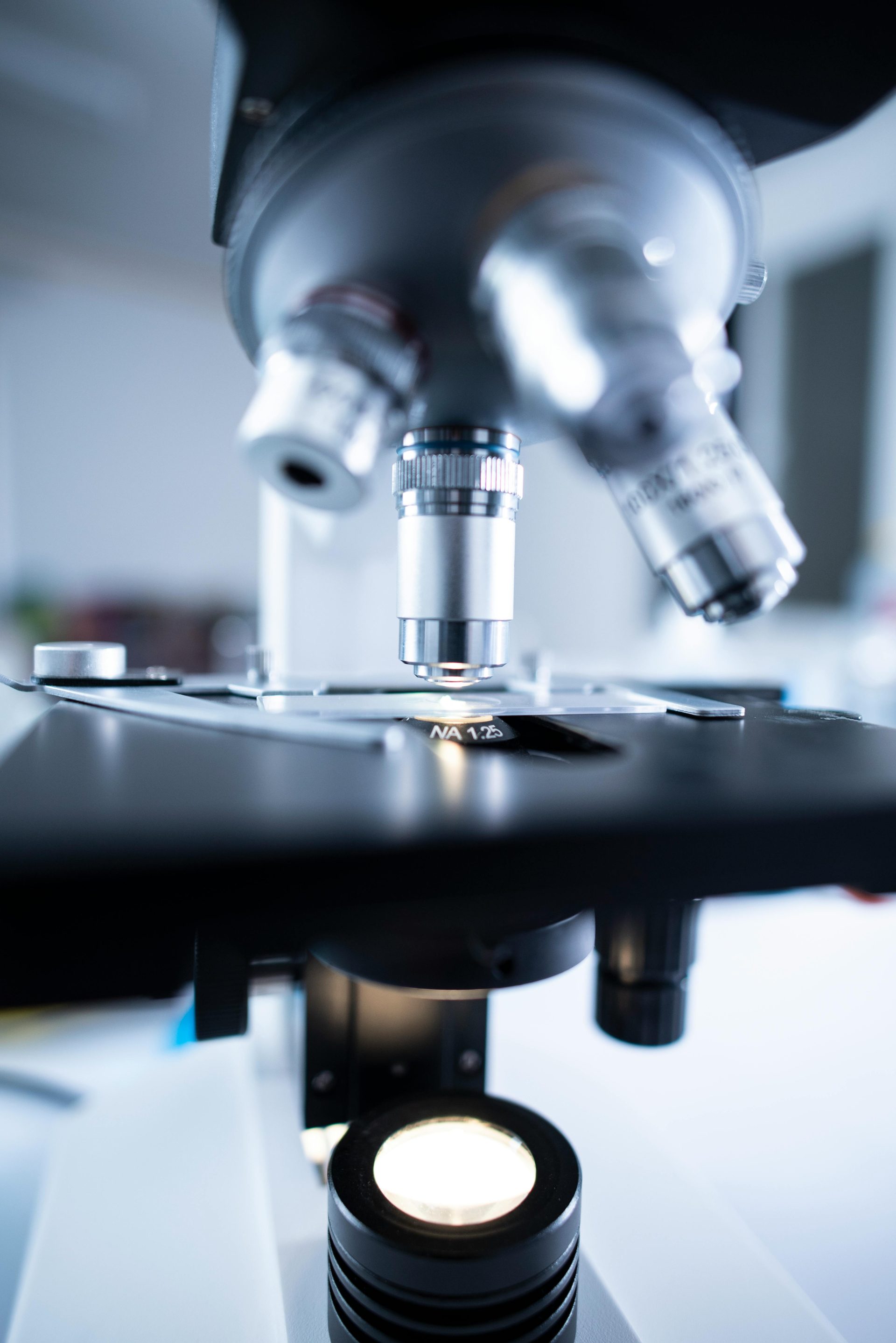 Detailansicht eines Labormikroskops mit Fokus auf Linse und optischen Komponenten.